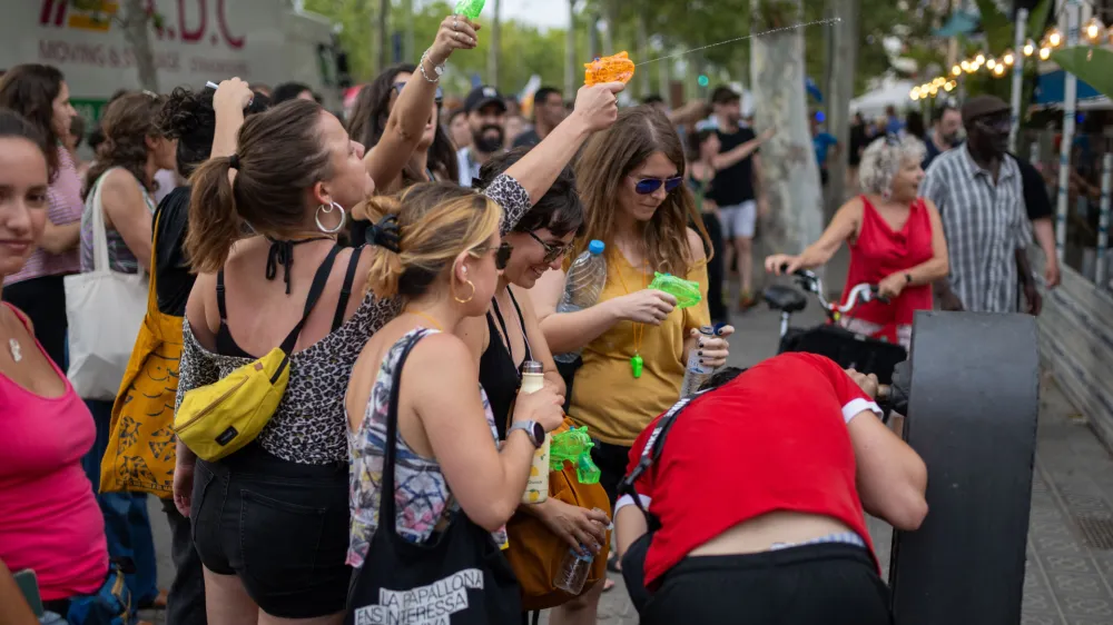 06 July 2024, Spain, Barcelona: People splash water on restaurants and cafes during a demonstration against mass tourism in Barcelona under the slogan 'Enough. Let's put a limit to tourism'. Photo: Lorena Sop&ecirc;na/EUROPA PRESS/dpa