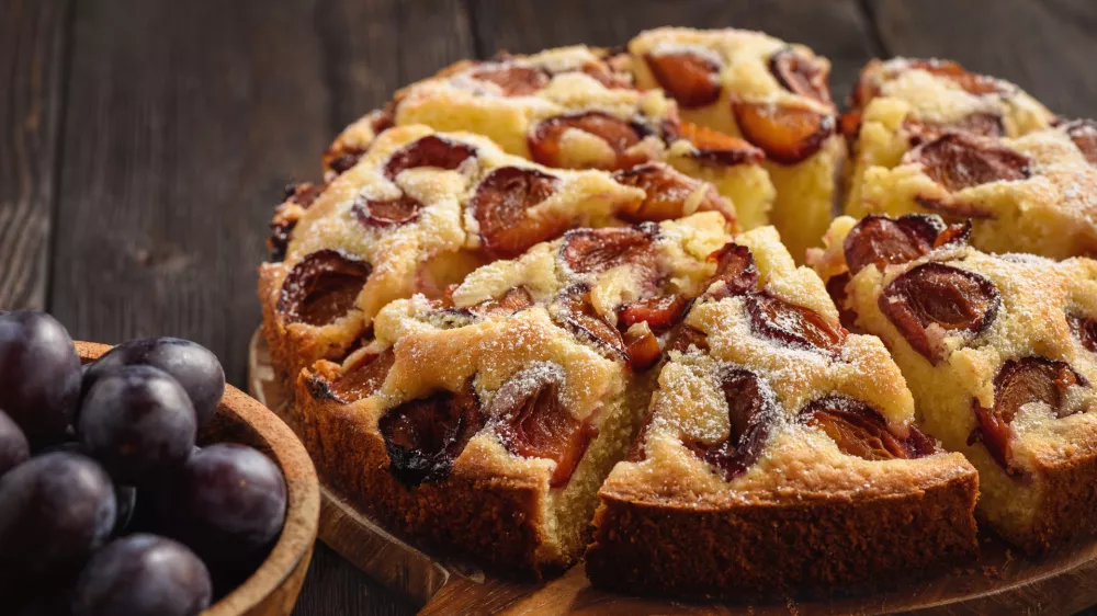 Homemade plum cake on dark wooden background. / Foto: Iko636