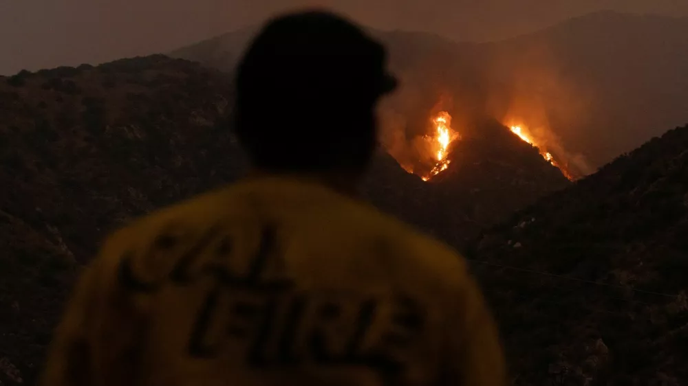 A firefighter monitors the progression of the Line Fire in the San Bernardino National Forest's mountains over Highland, California, U.S. September 8, 2024. REUTERS/Etienne Laurent