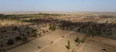 FILE PHOTO: Wheel loaders move soil to prepare a field for tree planting, at one of the sections of the Yangguan state-backed forest farm, on the edge of the Gobi desert, on the outskirts of Dunhuang, Gansu province, China, April 13, 2021. REUTERS/Carlos Garcia Rawlins/File Photo