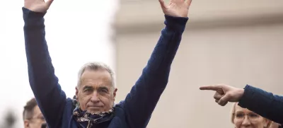 FILE - Calin Georgescu, the winner of the first round of presidential elections, later annulled by the Constitutional Court, waves to supporters during a protest, in Bucharest, Romania, March 1, 2025. (AP Photo/Vadim Ghirda, File)
