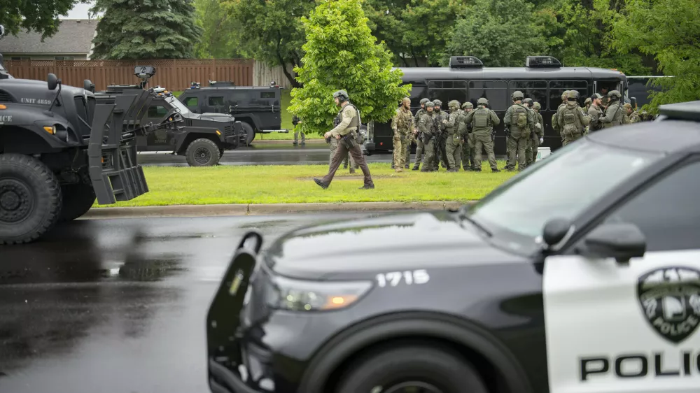 Law enforcement officers including local police, sheriffs and the FBI, stage less than a mile from a shooting in Brooklyn Park, Minn. on Saturday, June 14, 2025. (Alex Kormann/Star Tribune via AP)