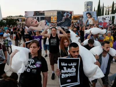 Demonstrators carry sacks of flour, during a protest demanding an end to the war in Gaza and the release of all hostages, in Tel Aviv, Israel, July 22, 2025. REUTERS/Ammar Awad