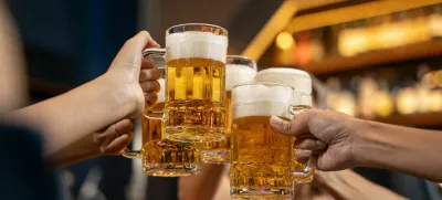 Close-up Group of People Holding Beer and Cheer in Restaurant. They Enjoying with Night Party Together. Party, Lifestyle, Happiness, Cheerful and Celebration Concept.