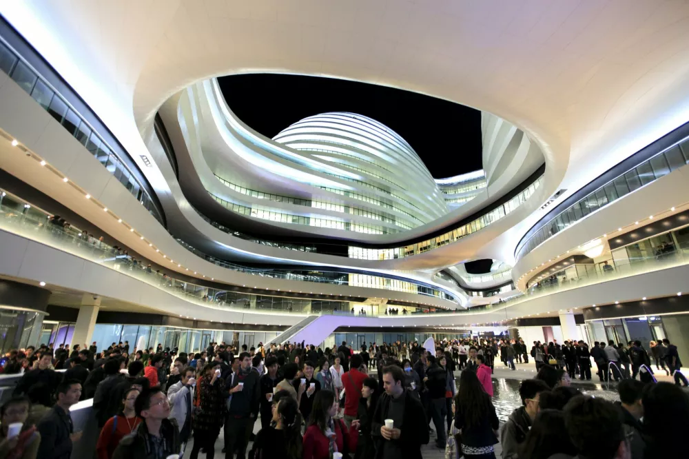 ﻿People visit the newly opened Galaxy Soho building, designed by Iraqi-British architect Zaha Hadid, in Beijing October 27, 2012. REUTERS/Jason Lee/Files