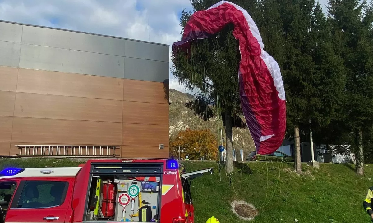 Poškodovana jadralna padalka obvisela na smreki