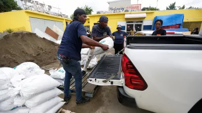 People load a sandbag onto a vehicle, in preparation for the arrival of Hurricane Melissa, in the Harbour View neighbourhood of Kingston, Jamaica, October 25, 2025. REUTERS/Octavio Jones