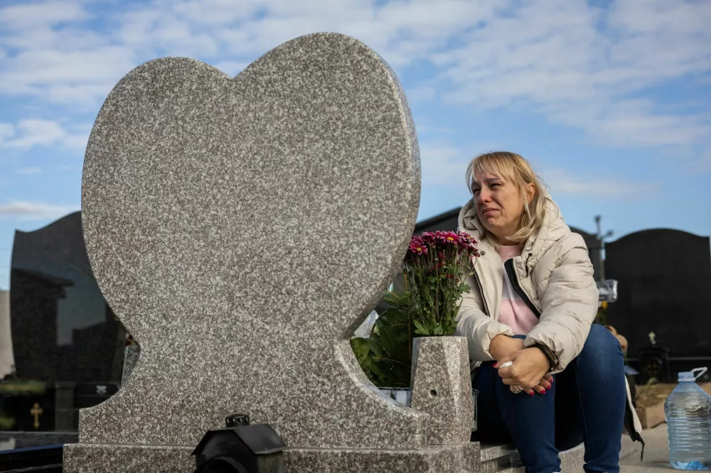 Dijana Hrka, 48, visits the grave of her son Stefan, who was among the 16 people killed in the fatal November 2024 Novi Sad railway station canopy collapse, which triggered nationwide accusations of widespread corruption and negligence, in Belgrade, Serbia, October 27, 2025. REUTERS/Marko Djurica
