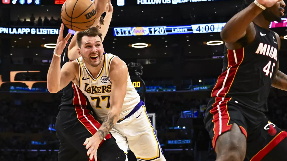 Nov 2, 2025; Los Angeles, California, USA; Los Angeles Lakers guard Luka Doncic (77) passes the ball against Miami Heat guard Pelle Larsson (9) during the second half at Crypto.com Arena. Mandatory Credit: Jonathan Hui-Imagn Images