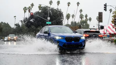 A vehicle crosses a flooded roadway in Pasadena, Calif., on Saturday, Nov. 15, 2025. (AP Photo/Noah Berger)