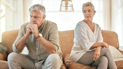Senior couple, divorce and disagreement in conflict, fight or argument on living room sofa at home. Elderly woman and frustrated man in depression, cheating affair or toxic relationship in the house