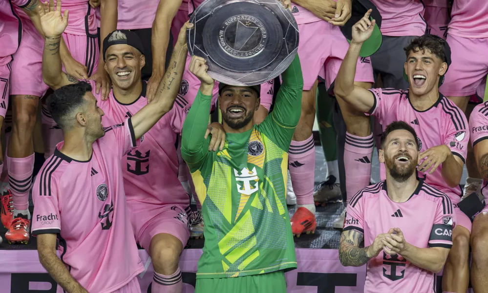 Inter Miami forward Lionel Messi, front right, celebrates with his teammates Sergio Busquets, front left, Luis Su&aacute;rez, second row, left, and Drake Callender, center in green, after winning the Supporters' Shield defeating the New England Revolution at Chase Stadium in Fort Lauderdale, Fla., Saturday, Oct. 19, 2024. (David Santiago/Miami Herald via AP)