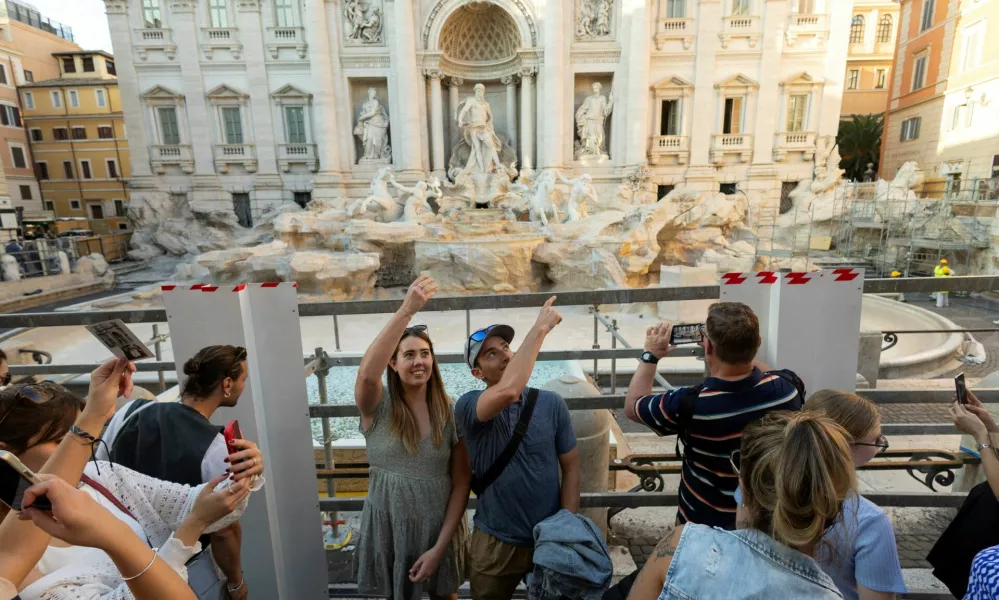 FILE PHOTO: People throw coins and wishes inside a pool as Trevi Fountain undergoes maintenance works in Rome, Italy, October 31, 2024. REUTERS/Remo Casilli/File Photo