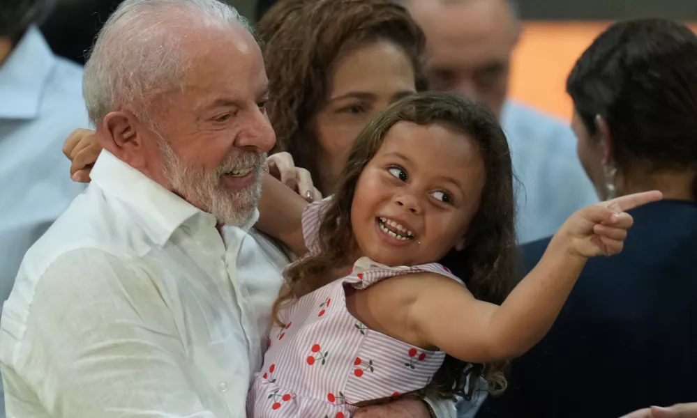 Brazilian President Luiz Inacio Lula da Silva hugs a child during a Christmas event with the families of collectors of recyclable trash in Sao Paulo, Friday, Dec. 19, 2025. (AP Photo/Andre Penner)