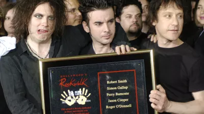 FILE - Robert Smith, left, Simon Gallup, center, and Perry Bamonte of British rock group The Cure hold a plaque after being inducted into Hollywood's Rockwalk in Los Angeles, Friday, April 30, 2004. (AP Photo/Chris Pizzello, File)