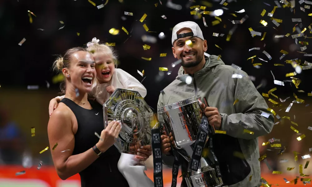 Tennis - 'Battle of the Sexes' - Nick Kyrgios v Aryna Sabalenka - Coca-Cola Arena, Dubai, United Arab Emirates - December 28, 2025 Belarus' Aryna Sabalenka, her goddaughter Nicole, and Australia's Nick Kyrgios celebrate with trophies after the match REUTERS/Amr Alfiky/Pool