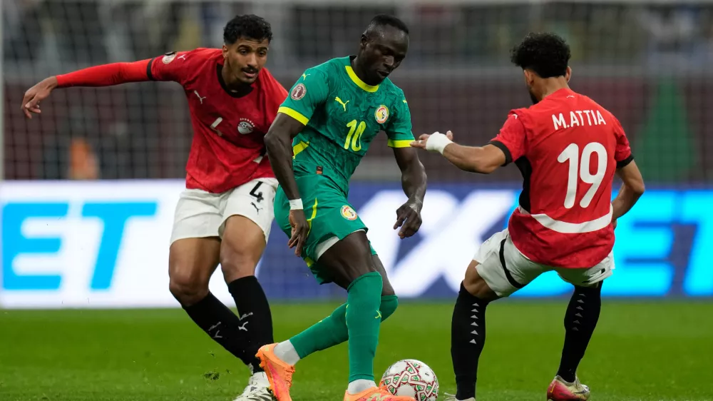 Senegal's Sadio Mane, center, is challenged by Egypt's Hossam Abdelmaguid, left, and Egypt's Marwan Attia during the Africa Cup of Nations semifinal soccer match between Senegal and Egypt, in Tangier, Morocco, Wednesday, Jan. 14, 2026. (AP Photo/Themba Hadebe)