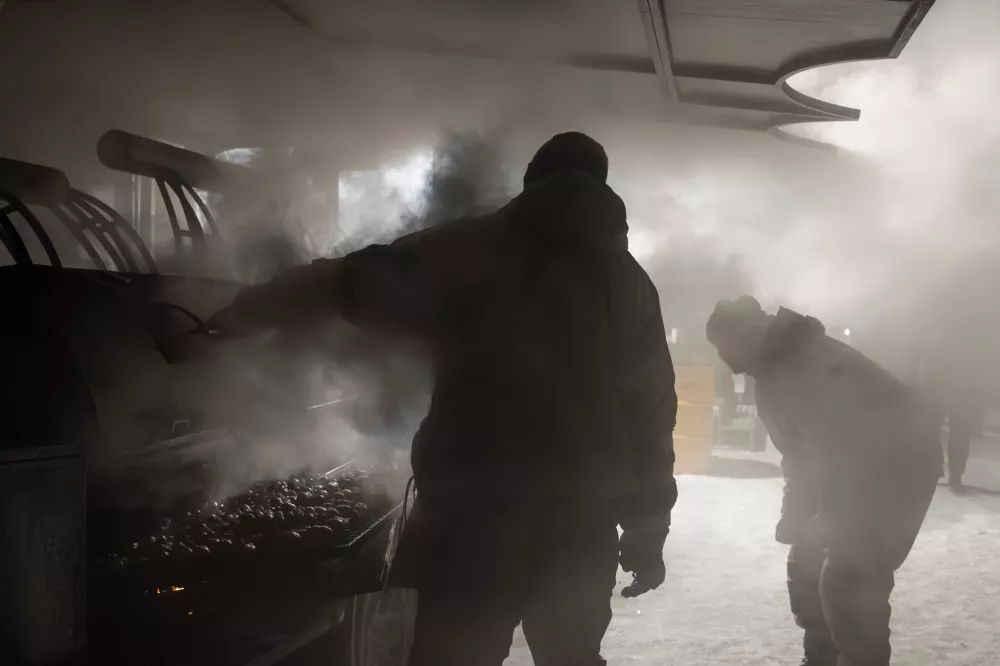 Veterans of the 3rd Separate Assault Brigade of Ukraine's Armed Forces serve free hot meals in a residential neighborhood for people without power in their homes in Kyiv, Ukraine, Saturday, Jan. 31, 2026.(AP Photo/Vladyslav Musiienko)