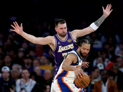 Los Angeles Lakers guard Luka Doncic, top, defends against New York Knicks guard Jalen Brunson, bottom, during the second half of an NBA basketball game, Sunday, Feb. 1, 2026, in New York. (AP Photo/John Munson)