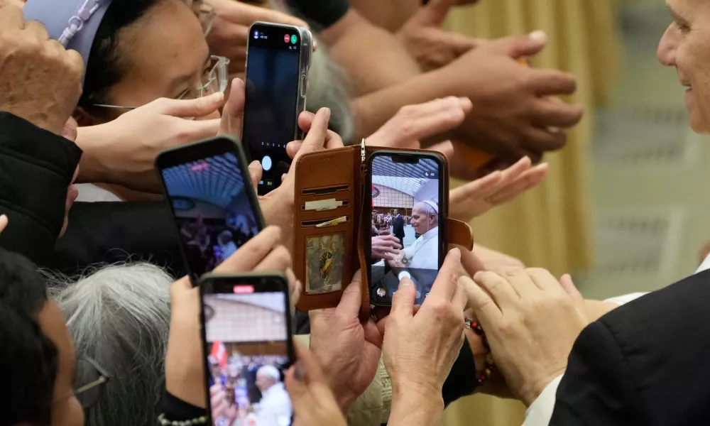 Faithful use their phones to take pictures as they try to reach for Pope Leo XIV hands at the end of the weekly general audience at the Vatican, Wednesday, Feb. 11, 2026. (AP Photo/Gregorio Borgia) / Foto: Gregorio Borgia