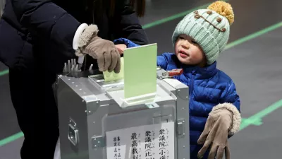 A boy looks on as his mother casts her ballot for a general election at a polling station in Tokyo, Japan, on February 8, 2026. REUTERS/Kim Kyung-Hoon