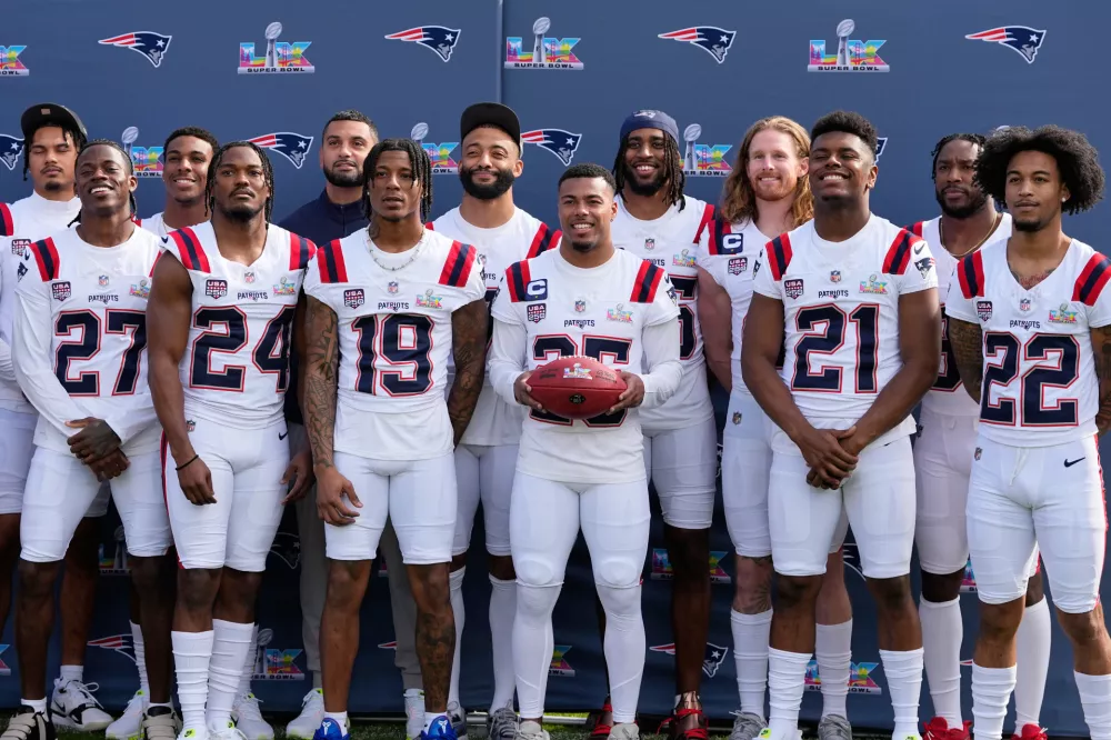 New England Patriots team members pose for a photo at the practice venue for their Super Bowl 60 NFL football game against the Seattle Seahawks, Saturday, Feb. 7, 2026, in Stanford, Calif. (AP Photo/Charlie Riedel)