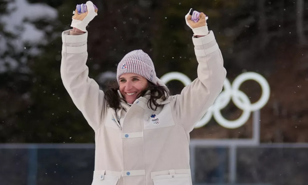 Julia Simon, of France, celebrates gold during a medals ceremony for the women's 15-kilometer individual biathlon race at the 2026 Winter Olympics in Anterselva, Italy, Wednesday, Feb. 11, 2026. (AP Photo/Andrew Medichini)
