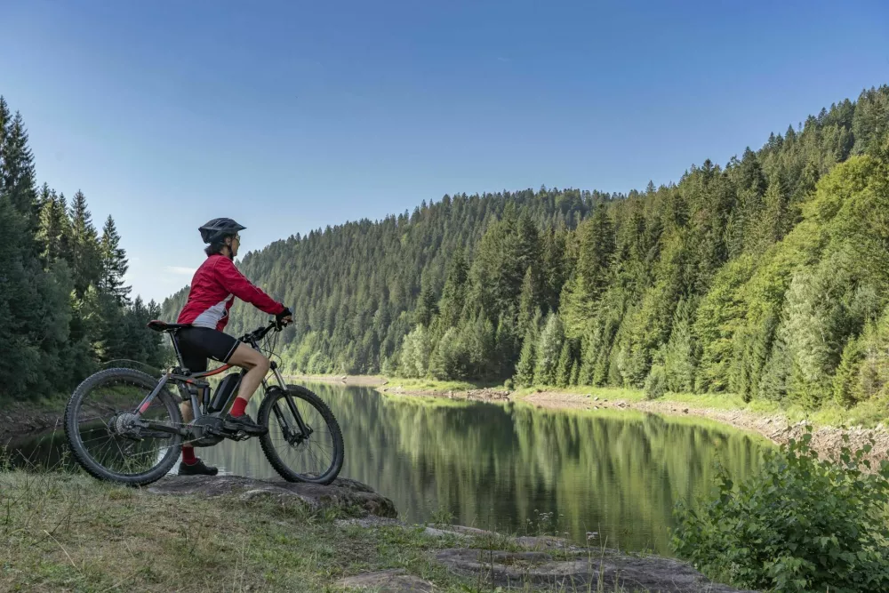 nice and ever young senior woman with her electric mountain bike at the Kinzig drinking Water reservoir in the northern Black Forest, Baden-Wuerttemberg, Germany / Foto: Uwe Moser