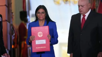 Acting President Delcy Rodriguez holds up an amnesty bill approved by the National Assembly alongside Interior Minister Diosdado Cabello at Miraflores Palace in Caracas, Venezuela, Thursday, Feb. 19, 2026. (AP Photo/Ariana Cubillos)