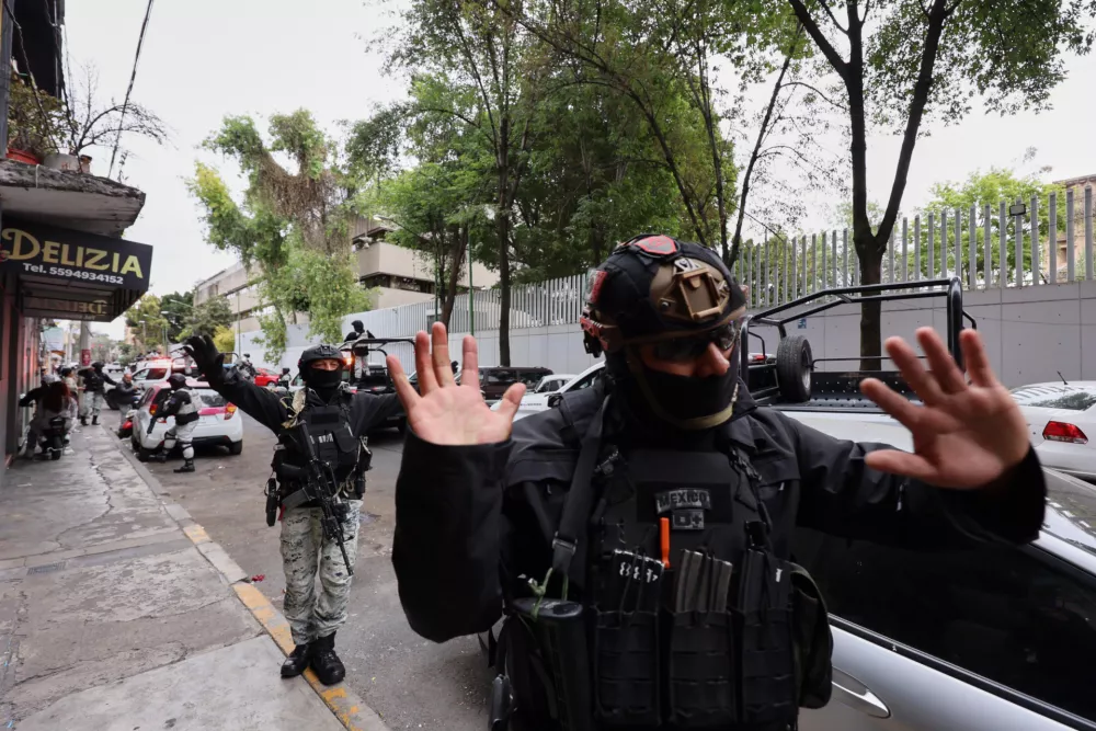 National Guards remove pedestrians by the General Prosecutor's headquarters in Mexico City, Sunday, Feb. 22, 2026, after the death of the leader of the Jalisco New Generation Cartel, Nemesio Rub&eacute;n Oseguera Cervantes, known as "El Mencho." (AP Photo/Ginette Riquelme)