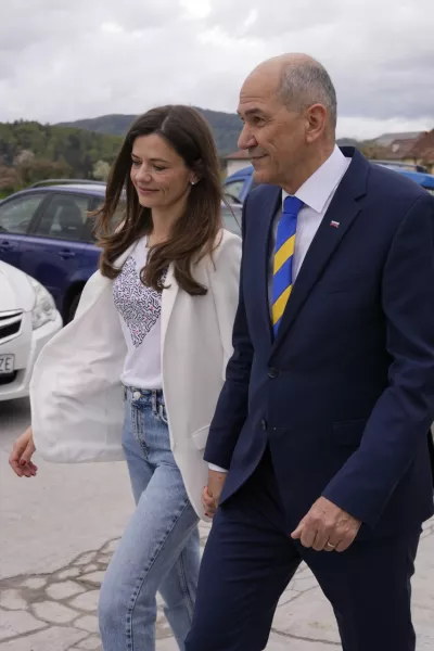 Slovenia's Prime Minister Janez Jansa with his wife Urska Bacovnik Jansa walks away from a polling station in Sentilj, Slovenia, Sunday, April 24, 2022. Slovenians cast ballots in a parliamentary election that is expected to be a tight race between Prime Minister Janez Jansa's ruling right-wing populists and liberals in the politically divided European Union nation. (AP Photo/Darko Bandic)