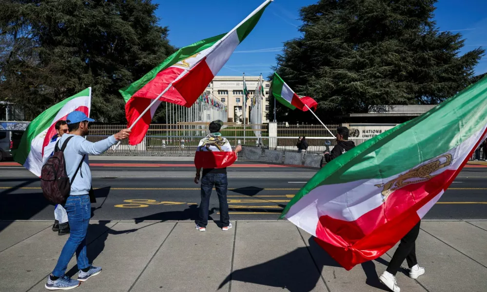Demonstrators hold the "Lion and Sun" pre-Iranian Revolution national flags during a protest against Iran's government in front of the United Nations Office at Geneva, on the day of a new round of indirect U.S.-Iran talks over their long-running nuclear dispute, in Geneva, Switzerland, February 26, 2026. REUTERS/Pierre Albouy