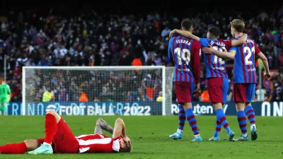 Barcelona's Frenkie de Jong, right, Barcelona's Jordi Alba, center, and Barcelona's Ferran Torres celebrate end of a Spanish La Liga soccer match between FC Barcelona and Atletico Madrid at the Camp Nou stadium in Barcelona, Spain, Sunday, Feb. 6, 2022. (AP Photo/Joan Monfort)