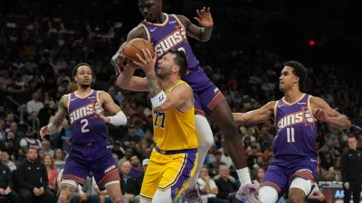 Los Angeles Lakers guard Luka Doncic drives between Phoenix Suns guard Amir Coffey (2), center Khaman Maluach, and forward Oso Ighodaro (11) during the second half of an NBA basketball game, Thursday, Feb. 26, 2026, in Phoenix. (AP Photo/Rick Scuteri)