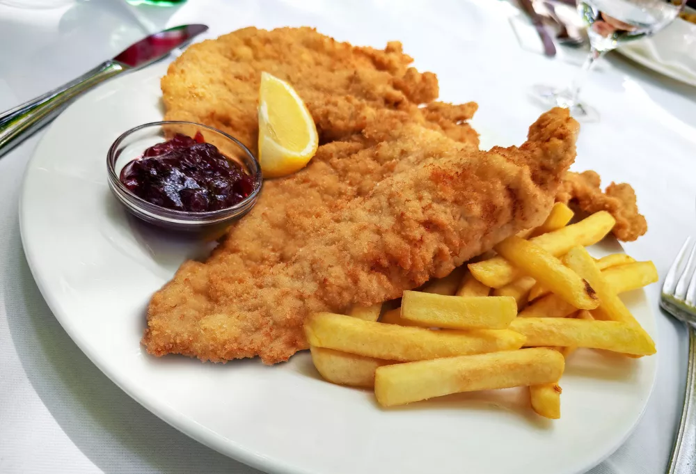 Plate with Schnitzel with French fries on white background / Foto: Antoniotruzzi