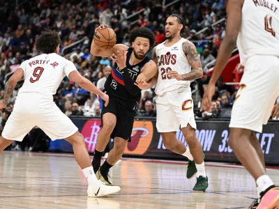 Feb 27, 2026; Detroit, Michigan, USA; Detroit Pistons guard Cade Cunningham (2) tries to drive between Cleveland Cavaliers guard Craig Porter Jr. (9) and Cleveland Cavaliers guard Jaylon Tyson (20) in the first half at Little Caesars Arena. Mandatory Credit: Lon Horwedel-Imagn Images
