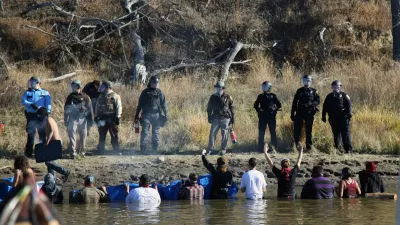 FILE - In this Nov. 2, 2016 file photo, protesters demonstrating against the expansion of the Dakota Access Pipeline wade in cold creek waters confronting local police as remnants of pepper spray waft over the crowd near Cannon Ball, N.D. (AP Photo/John L. Mone, File)