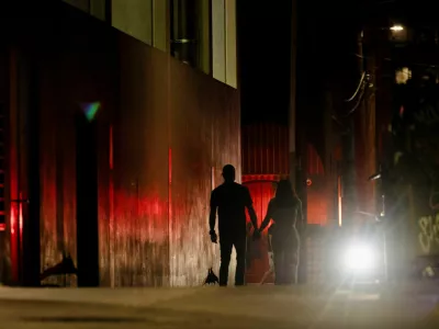 A couple makes their way around barricaded streets off Sixth Street after a deadly mass shooting outside Buford's, a popular roadhouse-style bar in Austin, Texas, U.S. March 1, 2026. REUTERS/Nuri Vallbona