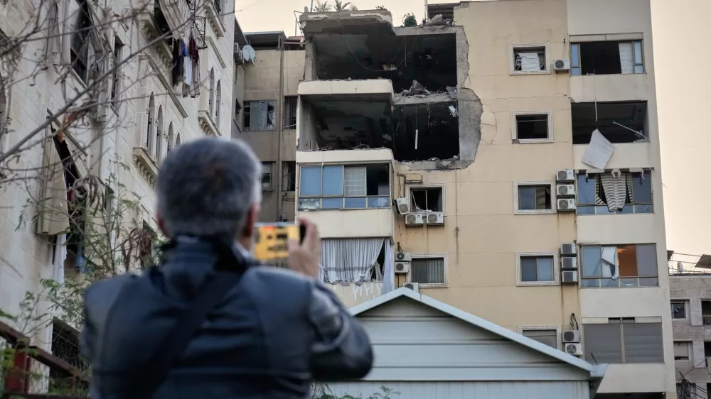 A man takes pictures of the damage in an apartment building after it was hit by an Israeli airstrike in Dahiyeh, Beirut's southern suburb, Lebanon, Monday, March 2, 2026. (AP Photo/Hussein Malla)