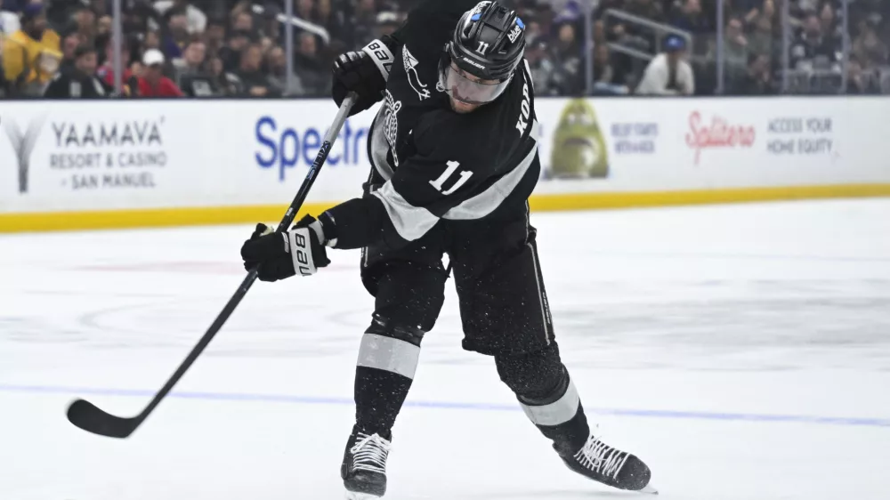 Feb 28, 2026; Los Angeles, California, USA; Los Angeles Kings center Anze Kopitar (11) shoots the puck during the second period against the Calgary Flames at Crypto.com Arena. Mandatory Credit: Griffin Hooper-Imagn Images