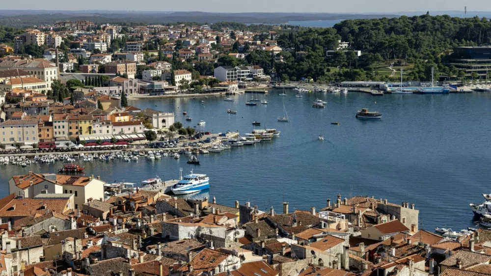 Rovinj; Croatia; Istria - September 29; 2023: Aerial view from bell tower of Saint Euphemia Church of port with moored boats. Typical red ceramic roof tile