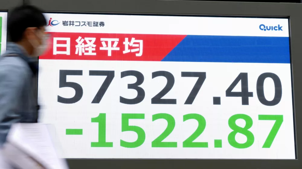 People walk in front of an electronic stock board showing Japan's Nikkei index at a securities firm Monday, March 1, 2026, in Tokyo.(Yohei Fukai/Kyodo News via AP)