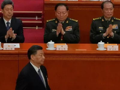 Chinese President Xi Jinping, bottom left, walks past then Vice Chairmen of China's Central Military Commission Zhang Youxia, top center, and He Weidong, top right, during a session of the National People's Congress (NPC) at the Great Hall of the People, in Beijing, China, March 12, 2023. (AP Photo/Andy Wong)