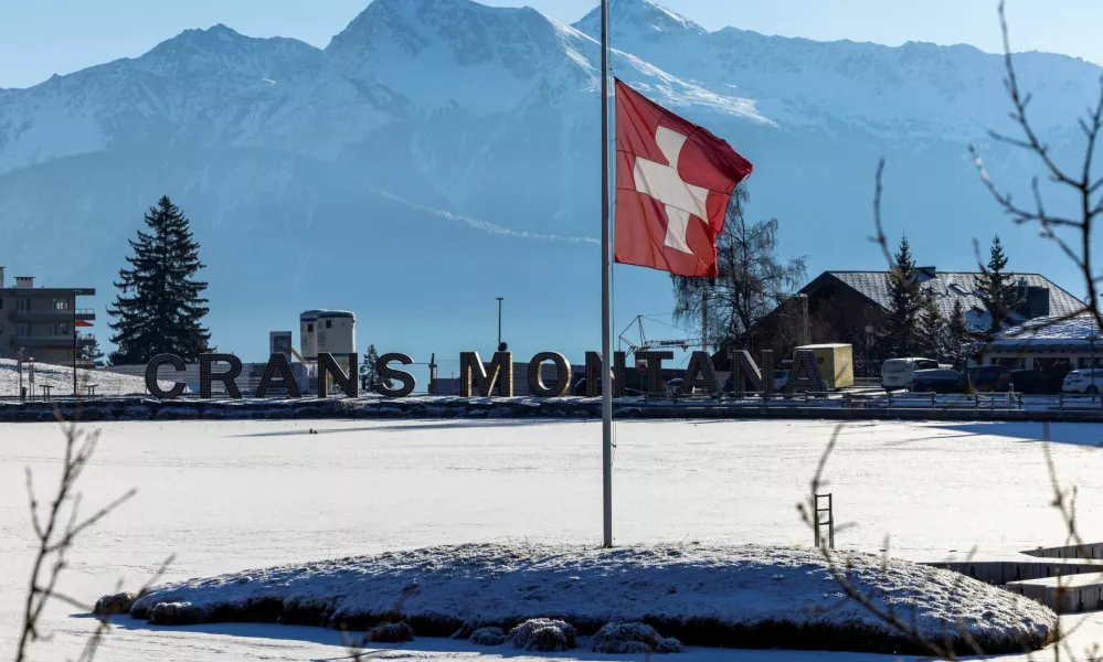 FILE PHOTO: A Swiss flag flutters at half-mast, after a deadly fire and explosion during a New Year's Eve party, in the upscale ski resort of Crans-Montana in southwestern Switzerland, January 7, 2026. REUTERS/Umit Bektas/File Photo