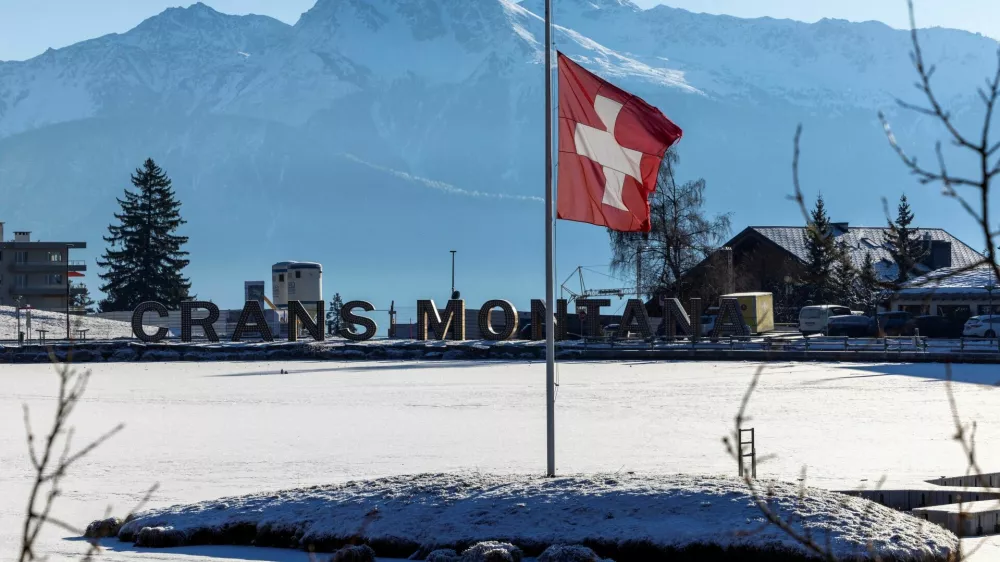 FILE PHOTO: A Swiss flag flutters at half-mast, after a deadly fire and explosion during a New Year's Eve party, in the upscale ski resort of Crans-Montana in southwestern Switzerland, January 7, 2026. REUTERS/Umit Bektas/File Photo