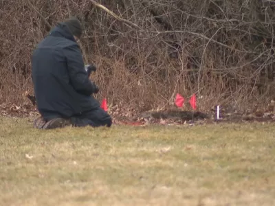 This image made from video provided by WEWS/News 5 shows an official examining a crime scene where the bodies of two young girls were found buried in suitcases, Tuesday, March 3, 2026, in Cleveland. (WEWS/News 5 via AP)