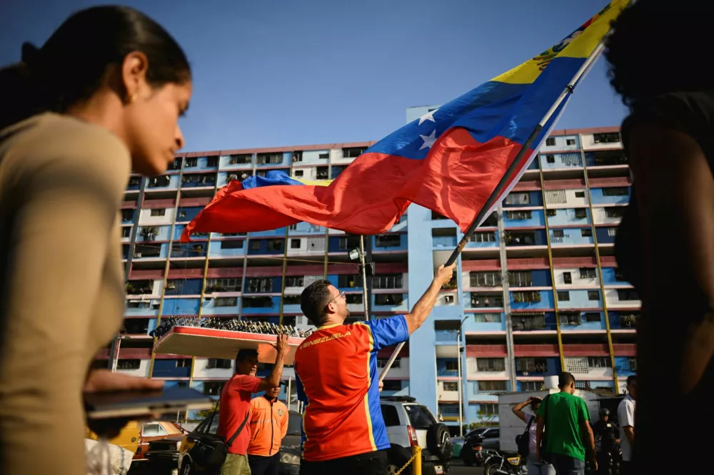 A supporter of Venezuela's government holds a Venezuelan flag during a rally to demand the release of ousted President Nicolas Maduro and his wife, Cilia Flores, two months after their capture by the U.S., in Caracas, Venezuela. March 3, 2026. REUTERS/Maxwell Briceno