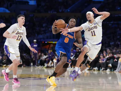 Mar 8, 2026; Los Angeles, California, USA; New York Knicks forward Og Anunoby (8) dribbles against Los Angeles Lakers center Jaxson Hayes (11) and forward Jake LaRavia (12) in the first half at Crypto.com Arena. Mandatory Credit: Kirby Lee-Imagn Images