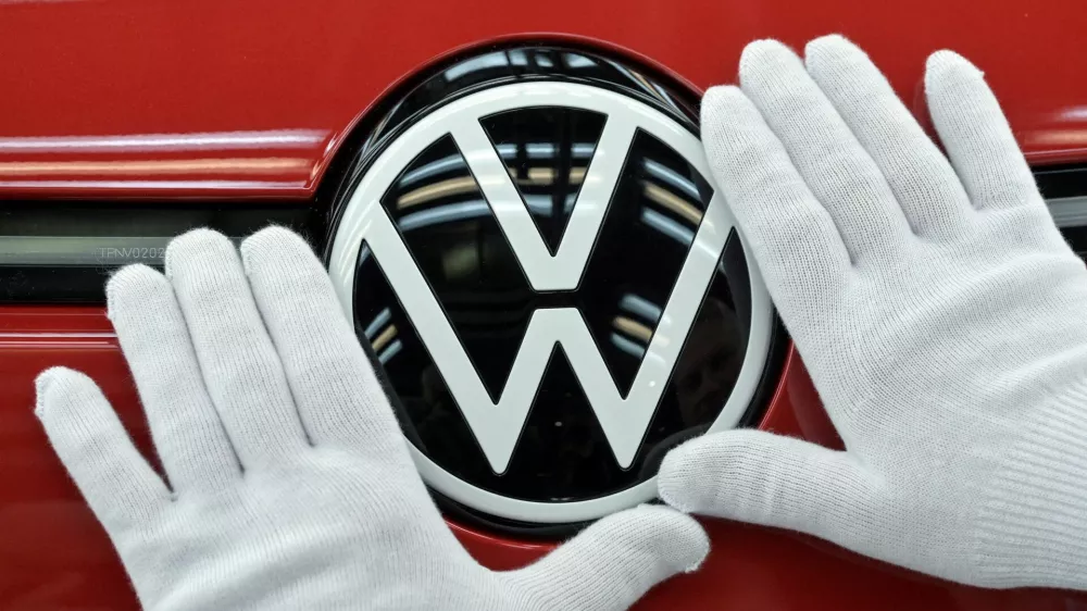 FILE PHOTO: A technician cleans the VW logo during the final inspection of German carmaker Volkswagen's electric ID. 3 car, during a media tour, in Dresden, Germany, May 14, 2025. REUTERS/Matthias Rietschel/File Photo