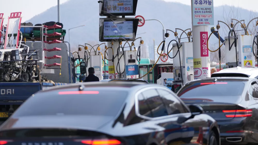 A man, center, fuels up a vehicle at a gas station in Seoul, South Korea, Tuesday, March 10, 2026. (AP Photo/Lee Jin-man)